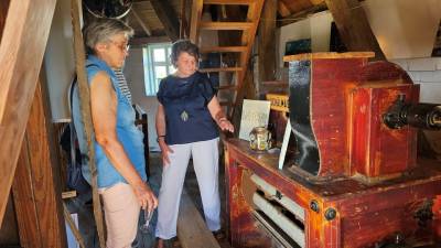 Christel Woitzick (re.) zeigt einer Besucherin eine Bild der Ausstellung